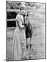 Woman Standing Next to a Pony in a Corral-null-Mounted Photo