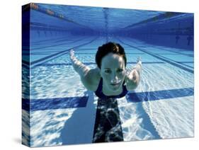 Woman Swimming Underwater in a Swimming Pool-null-Stretched Canvas