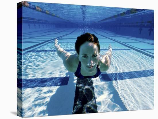 Woman Swimming Underwater in a Swimming Pool-null-Stretched Canvas