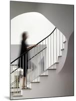 Woman walking up staircase holding handrail-John Edward Linden-Mounted Photo