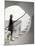 Woman walking up staircase holding handrail-John Edward Linden-Mounted Photo