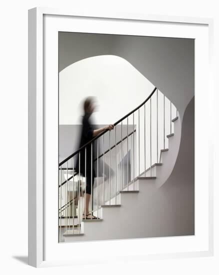 Woman walking up staircase holding handrail-John Edward Linden-Framed Photo