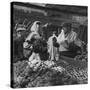 Woman with a Small Terrier Buying Bagels at a Market Stall, Possibly London, C.1945-50-null-Stretched Canvas