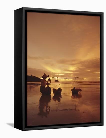 Woman with lamp and baskets on the beach, Phuket, Thailand-Luca Tettoni-Framed Stretched Canvas