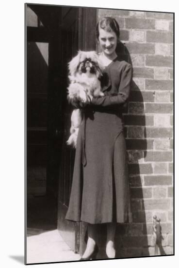 Woman with Pekingese Dog Outside a House-null-Mounted Photographic Print