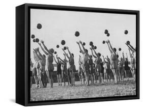 Women's Gym Class with Rows of Women Throwing Balls Into Air in Unison-null-Framed Stretched Canvas