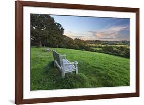 Wooden bench looking over green field countryside of High Weald on summer evening, Burwash-Stuart Black-Framed Photographic Print