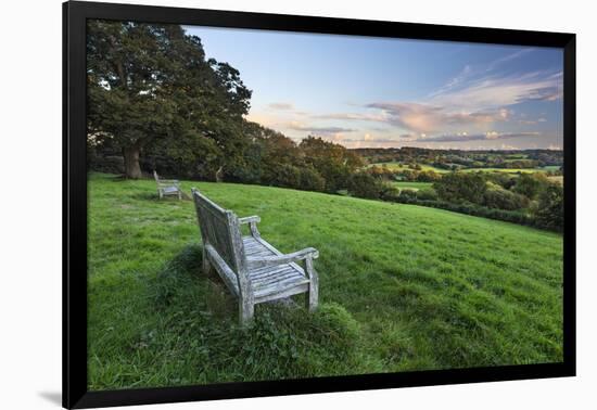 Wooden bench looking over green field countryside of High Weald on summer evening, Burwash-Stuart Black-Framed Photographic Print