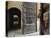 Wooden Fortified Gates and Alley of Medieval Town, Buonconvento, Italy-Dennis Flaherty-Stretched Canvas