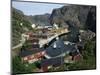 Wooden Red Houses on Stilts Over Water at the Fishing Village of Nusfjord, Lofoten Islands, Norway-Tony Waltham-Mounted Photographic Print