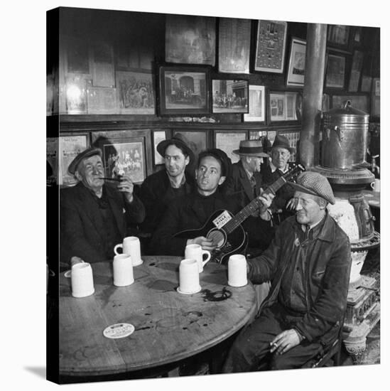 Woody Guthrie Playing and Singing for Patrons of Mcsorley's Bar-Eric Schaal-Stretched Canvas