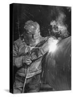 Worker Welding Pipe Used in Natural Gas Pipeline at World's Biggest Coal Fueled Generating Plant-Margaret Bourke-White-Stretched Canvas