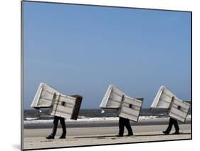 Workers Carry Beach Chairs Along the Beach of St. Peter-Ording at the North Sea, Northern Germany-null-Mounted Photographic Print