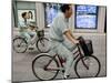 Workers Pedal Bicycles Past a Securities Firm in Tokyo-null-Mounted Photographic Print