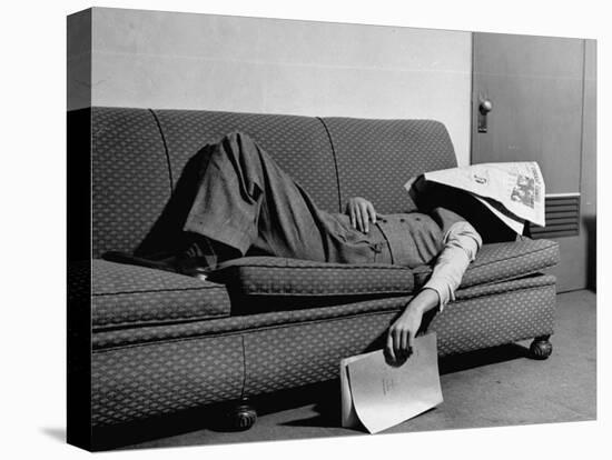 Writer Niven Busch Lying on Sofa with Newspaper over His Face as He Takes Nap from Screenwriting-Paul Dorsey-Stretched Canvas