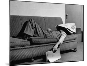 Writer Niven Busch Lying on Sofa with Newspaper over His Face as He Takes Nap from Screenwriting-Paul Dorsey-Mounted Photographic Print
