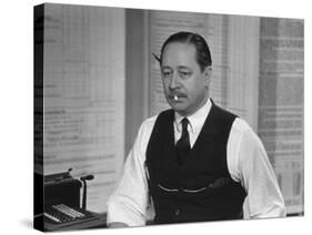 Writer Robert Benchley, Sitting at His Desk with a Small Wade of Paper in His Mouth-Bernard Hoffman-Stretched Canvas