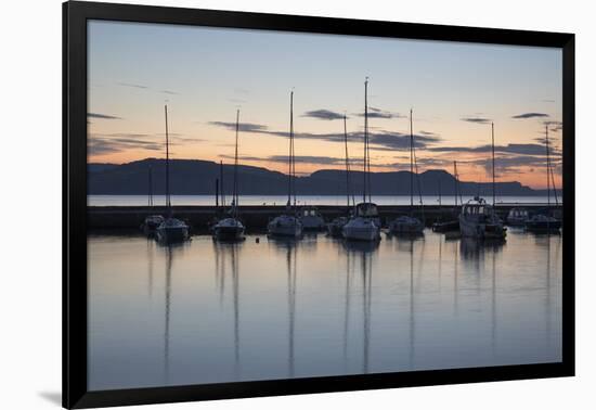 Yachts moored in The Cobb with Jurassic Coast and Golden Cap at sunrise, Lyme Regis, Dorset, Englan-Stuart Black-Framed Photographic Print