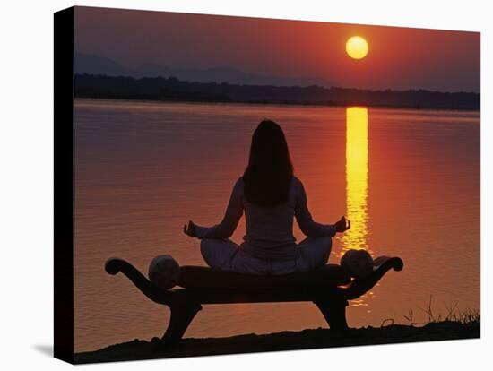 Yoga on a Saddle Bench Watching the Sun Go Down across the Zambesi River, Zambia-John Warburton-lee-Stretched Canvas