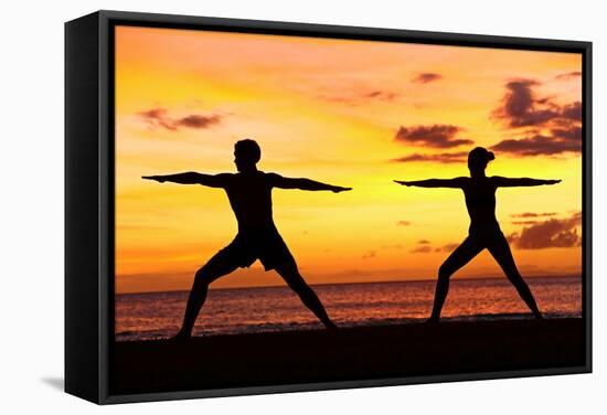 Yoga People Training and Meditating in Warrior Pose Outside by Beach at Sunrise or Sunset-Maridav-Framed Stretched Canvas