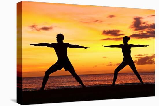 Yoga People Training and Meditating in Warrior Pose Outside by Beach at Sunrise or Sunset-Maridav-Stretched Canvas