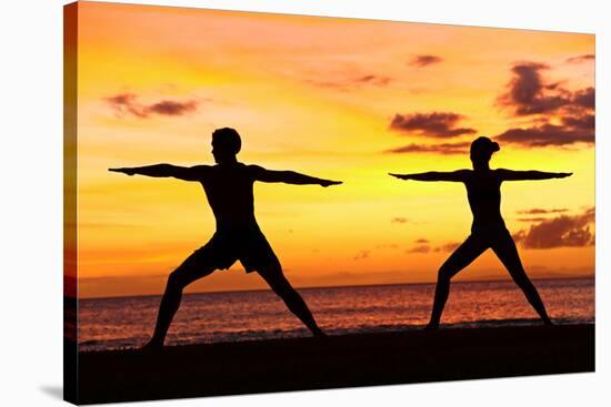 Yoga People Training and Meditating in Warrior Pose Outside by Beach at Sunrise or Sunset-Maridav-Stretched Canvas