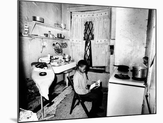 Young African American Studies by Kitchen Stove Because His Apartment Is Without Heat-null-Mounted Photo