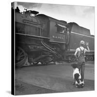 Young Boy and His Dog Standing at the Crossing as a Train Rides Through-Myron Davis-Stretched Canvas