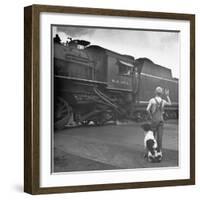 Young Boy and His Dog Standing at the Crossing as a Train Rides Through-Myron Davis-Framed Photographic Print