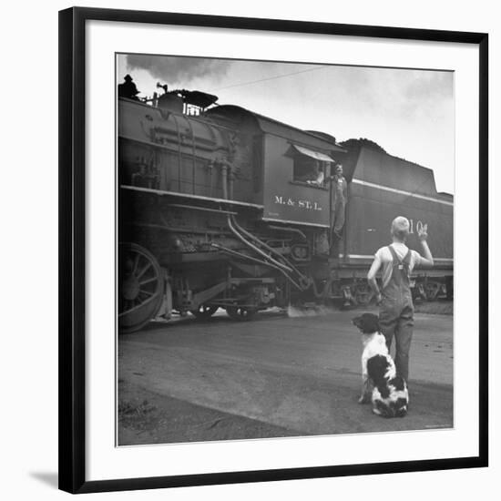 Young Boy and His Dog Standing at the Crossing as a Train Rides Through-Myron Davis-Framed Photographic Print