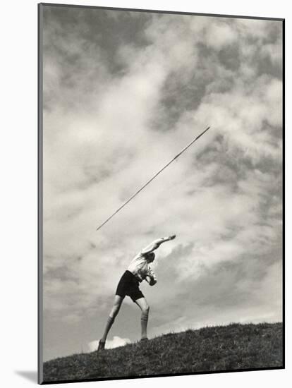 Young Boy Atop a Hill Hurls a Javelin into the Air-null-Mounted Photographic Print