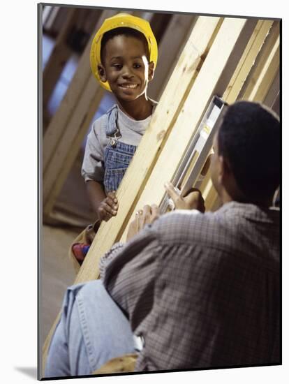 Young Boy in a Hard Hat Smiling at His Father-null-Mounted Photographic Print