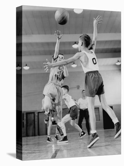 Young Boy Shooting a Free-Throw Shot over the Head of Another Young Boy-null-Stretched Canvas