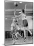 Young Boy Shooting a Free-Throw Shot over the Head of Another Young Boy-null-Mounted Photographic Print