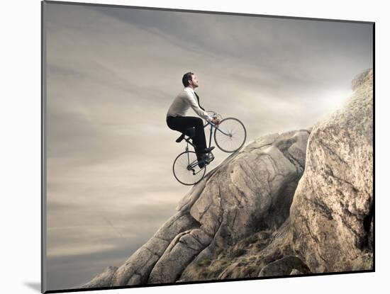 Young Businessman Pedaling a Bicycle on the Rocks-olly2-Mounted Photographic Print