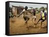 Young Children Play Soccer on a Dirt Pitch by the Side of Railway Tracks-null-Framed Stretched Canvas