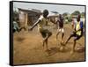 Young Children Play Soccer on a Dirt Pitch by the Side of Railway Tracks-null-Framed Stretched Canvas