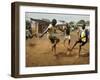 Young Children Play Soccer on a Dirt Pitch by the Side of Railway Tracks-null-Framed Premium Photographic Print