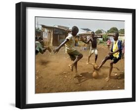 Young Children Play Soccer on a Dirt Pitch by the Side of Railway Tracks-null-Framed Premium Photographic Print