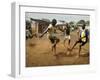 Young Children Play Soccer on a Dirt Pitch by the Side of Railway Tracks-null-Framed Premium Photographic Print