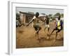 Young Children Play Soccer on a Dirt Pitch by the Side of Railway Tracks-null-Framed Photographic Print