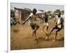 Young Children Play Soccer on a Dirt Pitch by the Side of Railway Tracks-null-Framed Photographic Print