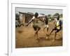 Young Children Play Soccer on a Dirt Pitch by the Side of Railway Tracks-null-Framed Photographic Print