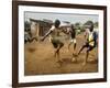 Young Children Play Soccer on a Dirt Pitch by the Side of Railway Tracks-null-Framed Photographic Print