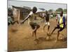 Young Children Play Soccer on a Dirt Pitch by the Side of Railway Tracks-null-Mounted Photographic Print