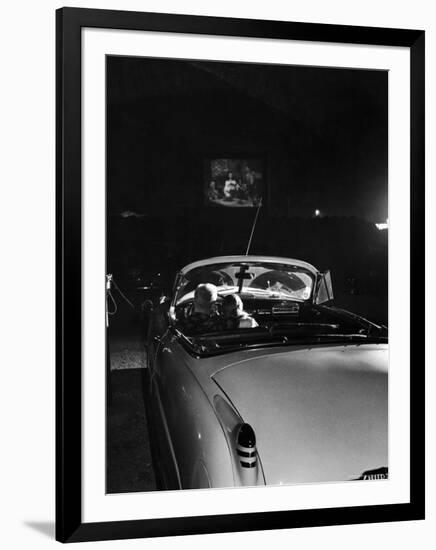 Young Couple Cuddling as They Watch a Movie at Drive in Theater-Francis Miller-Framed Photographic Print