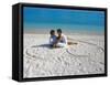 Young Couple on Beach Sitting in a Heart Shaped Imprint on the Sand, Maldives, Indian Ocean, Asia-Sakis Papadopoulos-Framed Stretched Canvas