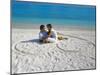 Young Couple on Beach Sitting in a Heart Shaped Imprint on the Sand, Maldives, Indian Ocean, Asia-Sakis Papadopoulos-Mounted Photographic Print