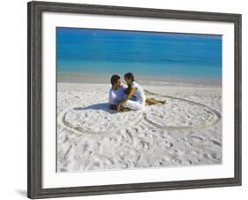 Young Couple on Beach Sitting in a Heart Shaped Imprint on the Sand, Maldives, Indian Ocean, Asia-Sakis Papadopoulos-Framed Photographic Print