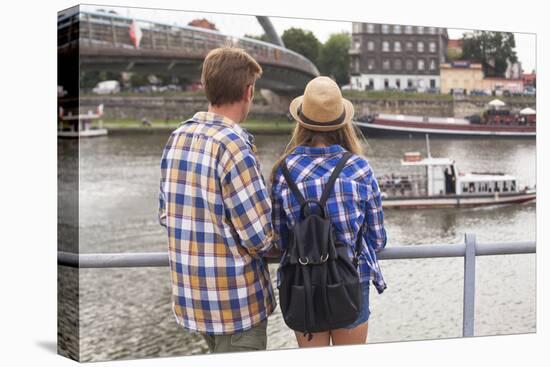 Young Couple on the River Bank in a European City (Rear View) Romantic Journey.-De Visu-Stretched Canvas
